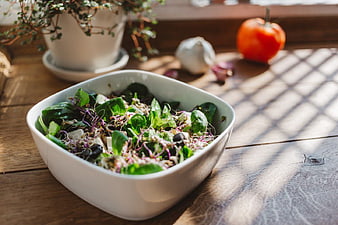 Fresh Green Salad Bowl on Wooden Table with Sunlight