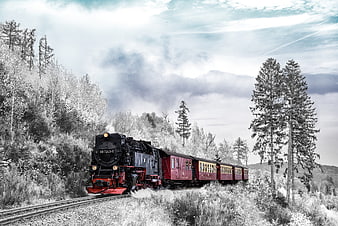 Vintage Steam Locomotive Pulling Red Carriages Through Snowy Forest Landscape