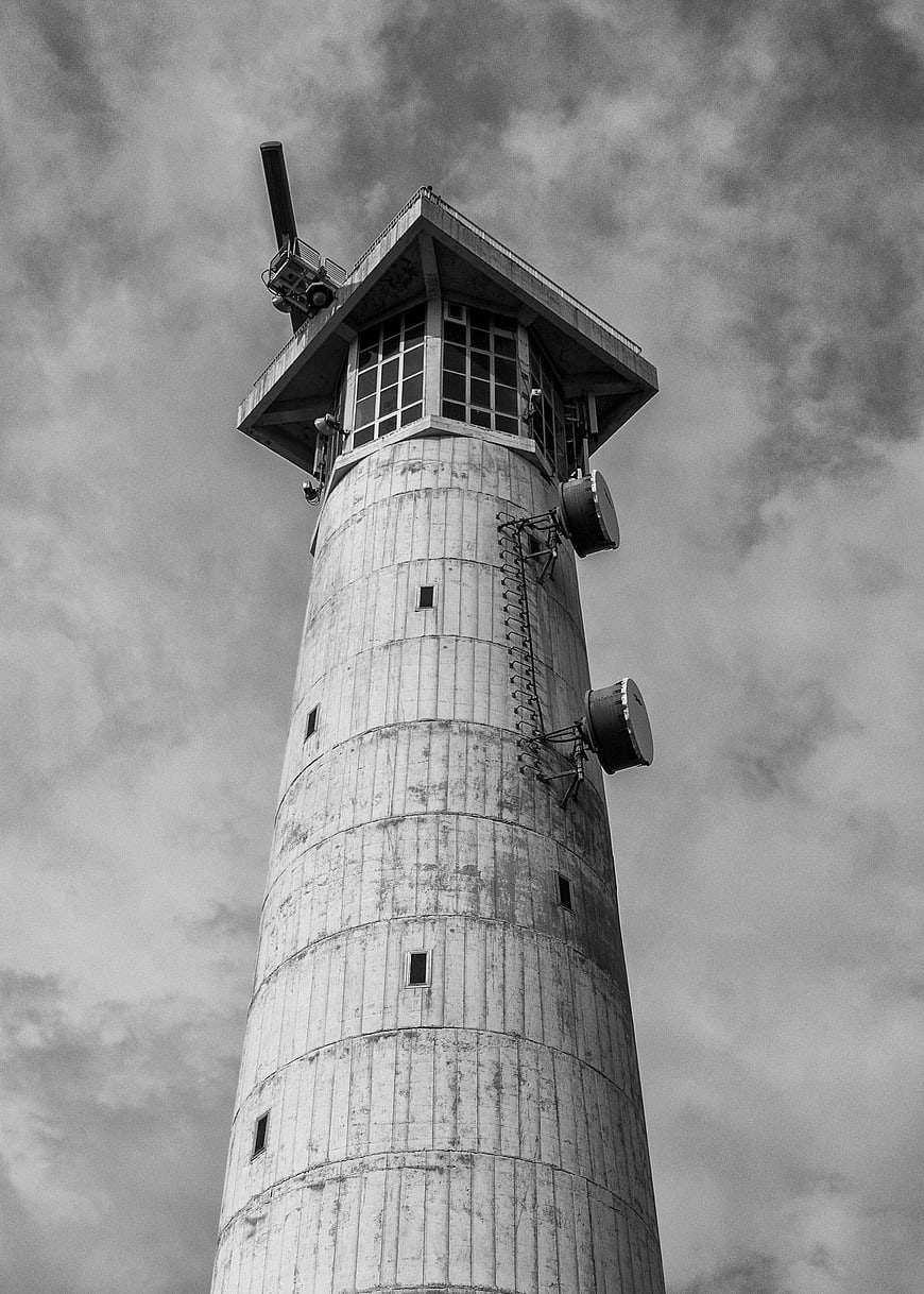 Low angle black and white view of concrete lighthouse tower