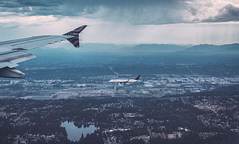 Airplane Wing View Over City and Mountains