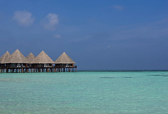 Overwater bungalows on turquoise lagoon with blue sky