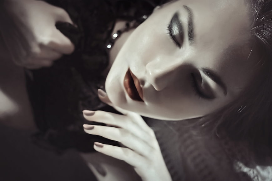 Close-up portrait of a woman with closed eyes and dramatic makeup