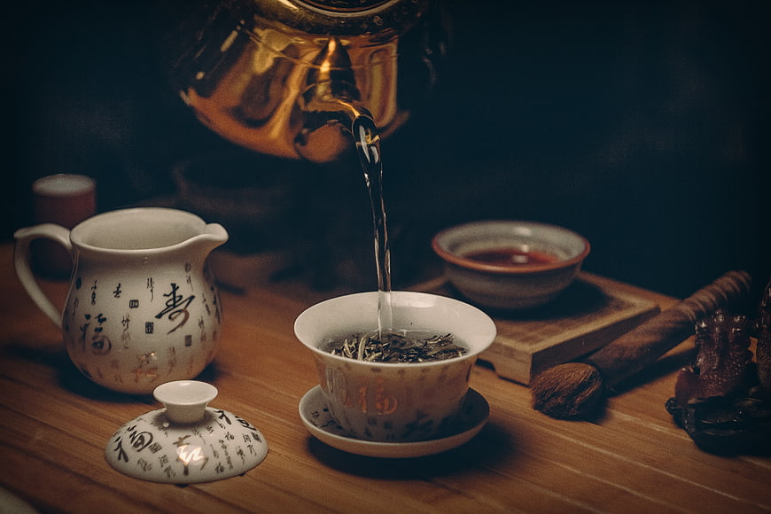 Pouring hot water into traditional Chinese tea cup