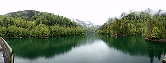 Panoramic View of Serene Green Mountain Lake with Forested Hills