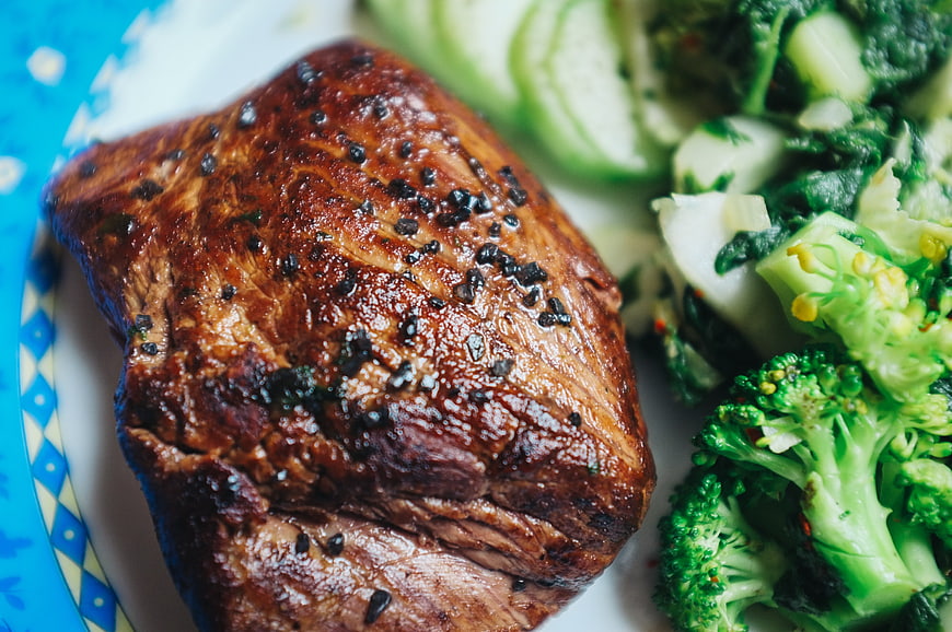 Close-up of grilled beef steak with broccoli and cucumber