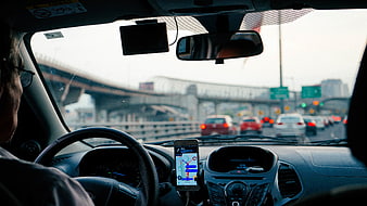 Driver using smartphone GPS navigation in car traffic