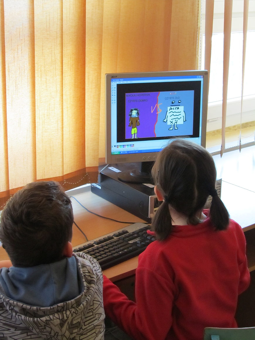 Two children drawing digital art on a computer
