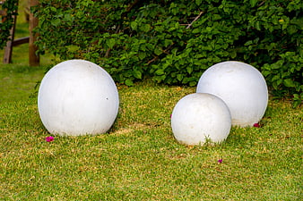 White decorative garden spheres on green lawn