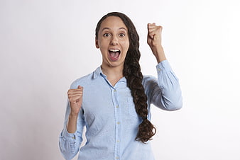 Excited young woman celebrating success with raised fists