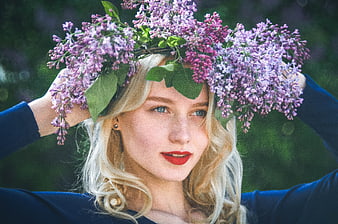 Blonde woman wearing a lilac flower crown in nature