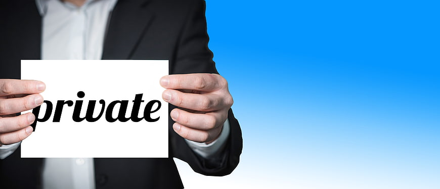 Businessman holding white card with private text against blue background