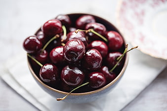 Fresh Dark Cherries In Ceramic Bowl On White Linen