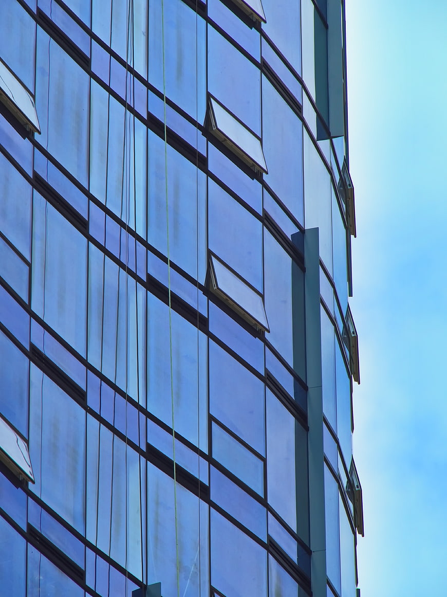 Modern Glass Office Building Facade with Blue Sky