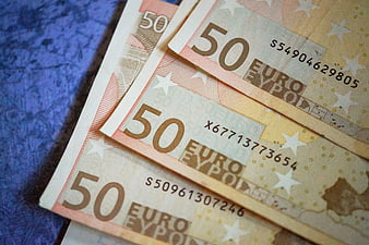 Close-up of 50 Euro banknotes on blue background