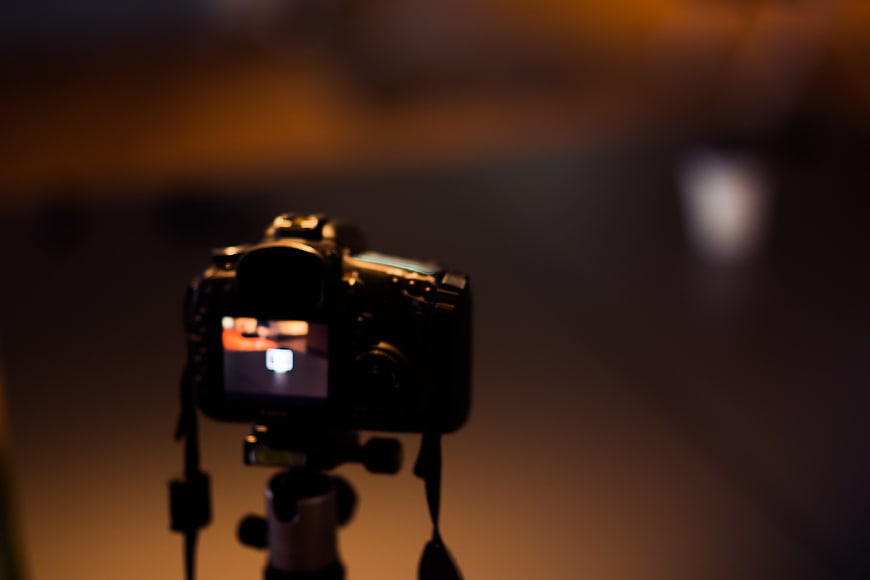 DSLR Camera on Tripod in Dark Room with Bokeh