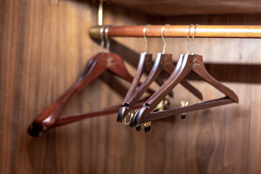 Empty wooden hangers in a luxury wardrobe closet interior