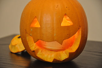 Carved Jack-O'-Lantern with Candle Light on Dark Table