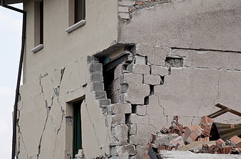 Damaged building wall with rubble and cracks