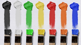 Colorful Paint Brushes with Swatches on White Wall