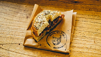 Bagel Sandwich on Brown Paper Wrapper on Wooden Table