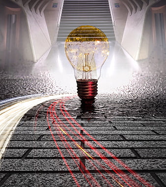 Glowing light bulb on wet cobblestone street with light trails