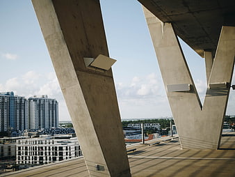 Modern Concrete Bridge Pillars with City Skyline Background