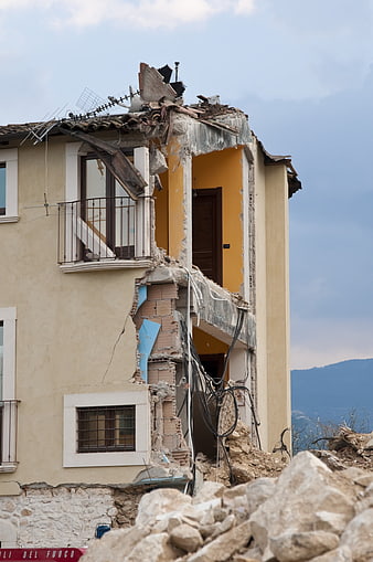 Collapsed Residential Building Facade With Exposed Interior Walls And Rubble