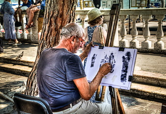 Senior artist sketching architecture on easel in Venice
