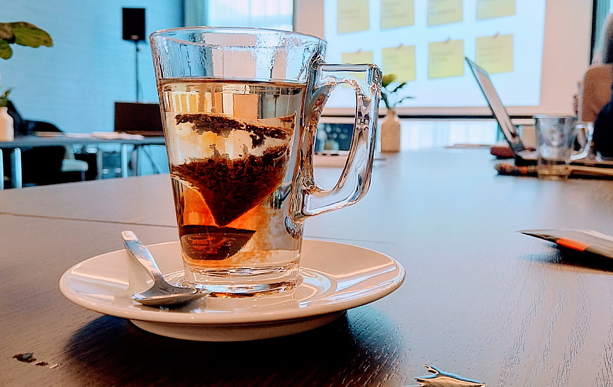 Glass mug with tea bag on office table