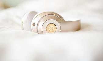 Gold and White Headphones on White Bed Sheets