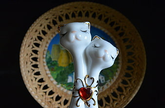 Close-up of white porcelain cat figurines with red heart