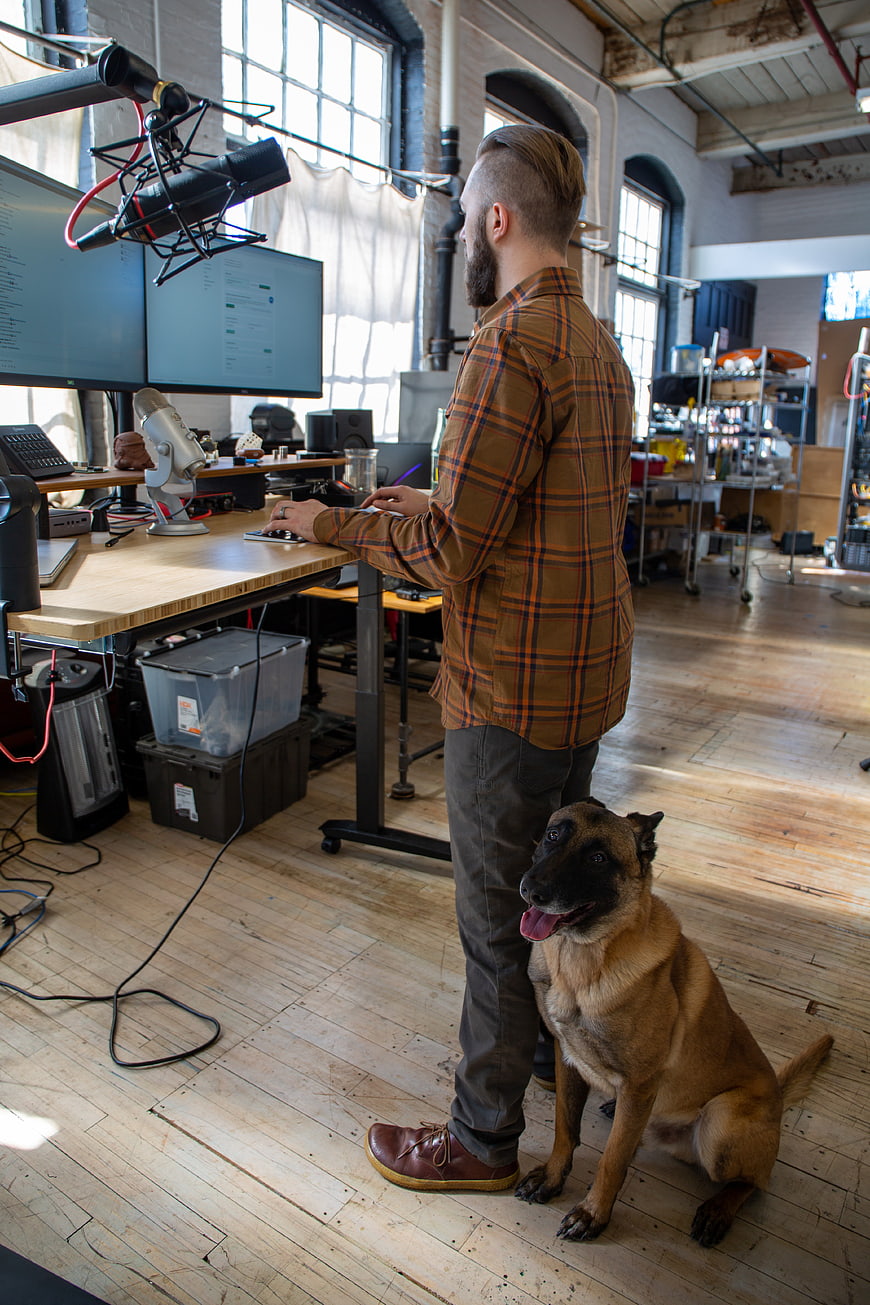 Man working at standing desk with dog in studio