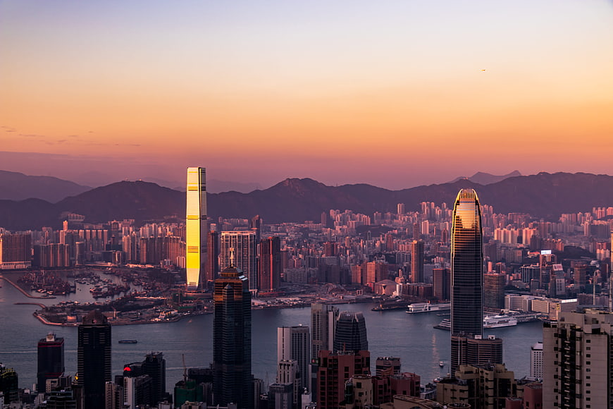 Hong Kong skyline at sunset with skyscrapers and harbor
