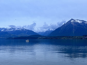 Serene Lake Landscape with Snow-Capped Mountains and Boat