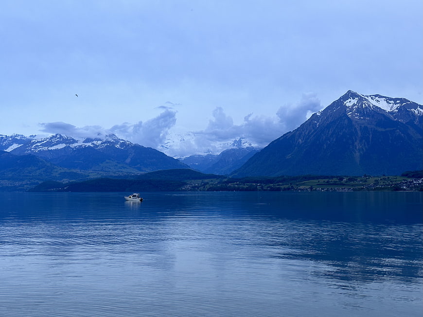 Serene Lake Landscape with Snow-Capped Mountains and Boat