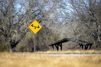 Yellow playground warning sign with seesaw symbol in park