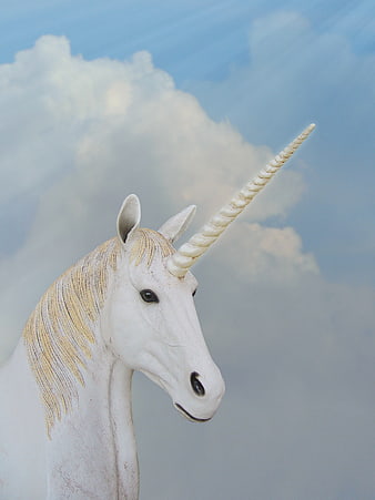 White Unicorn Statue Head Against Blue Sky With Clouds