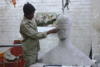 Artist Sculpting Clay Bust in Workshop