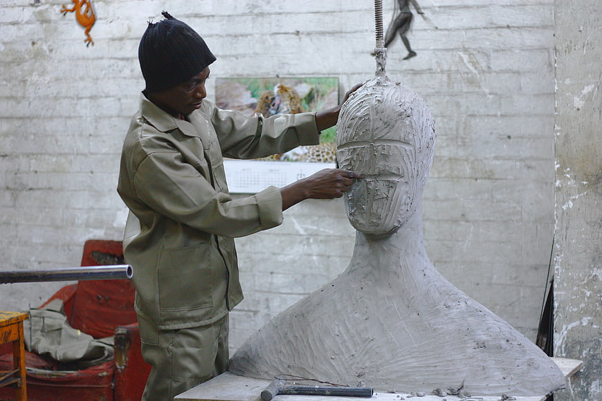 Artist Sculpting Clay Bust in Workshop