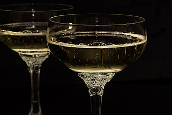 Two champagne glasses with sparkling wine on black background