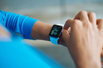 Close-up of person checking smartwatch with blue band