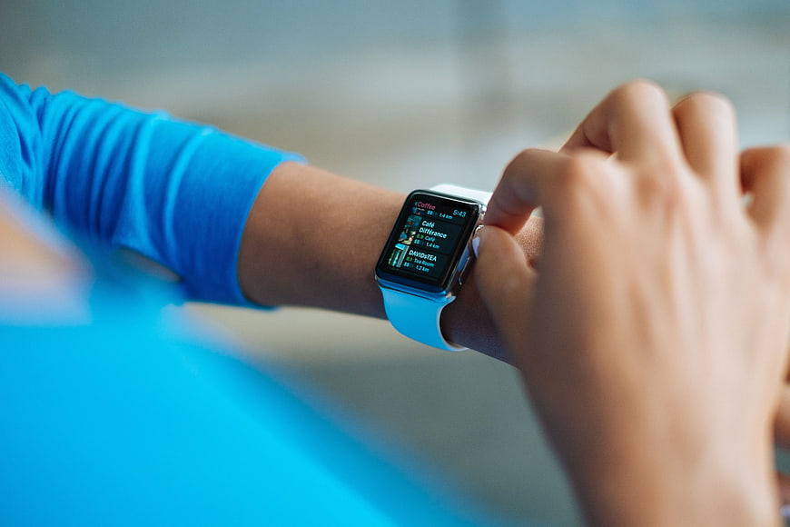 Close-up of person checking smartwatch with blue band