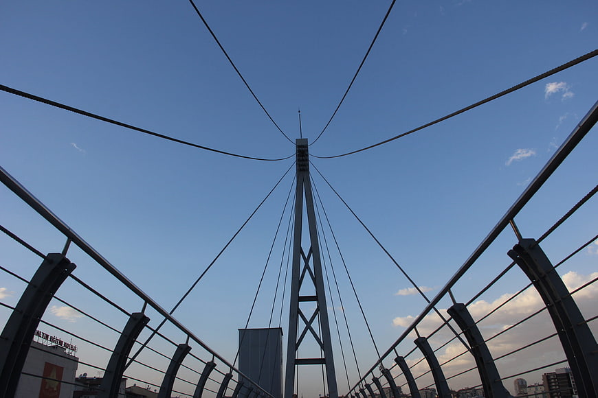 Low angle view of cable-stayed bridge tower against blue sky