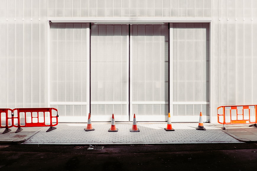 Orange Traffic Cones and Barriers in Front of White Building