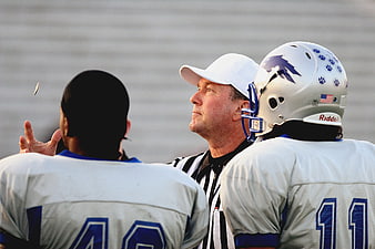 Football referee flipping coin for toss decision
