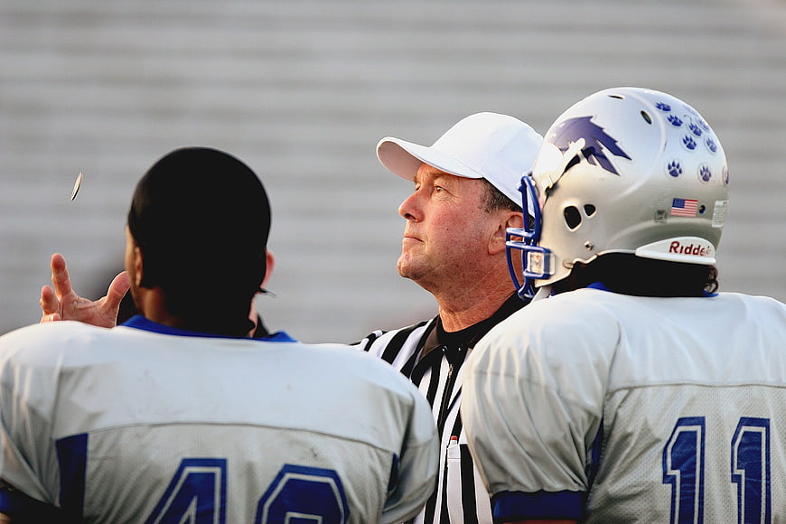 Football referee flipping coin for toss decision