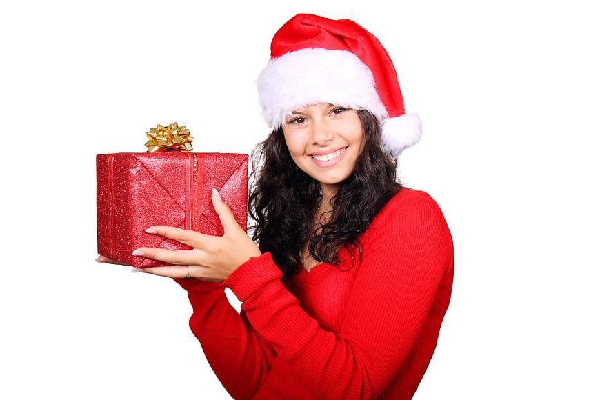 Happy Woman in Santa Hat Holding Red Christmas Gift Box