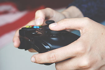 Close-up of hands holding a black video game controller