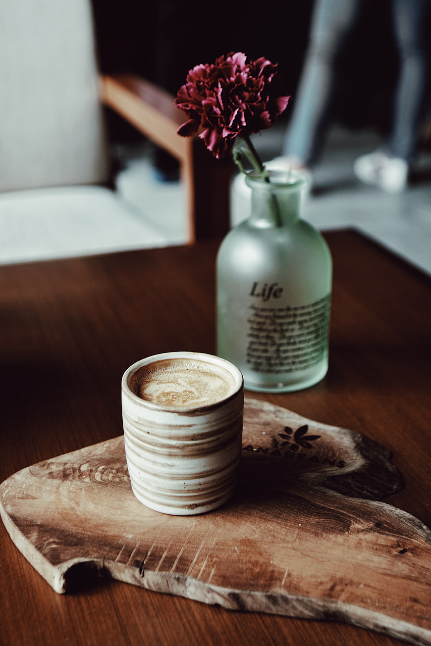 Rustic coffee cup and flower on wooden table