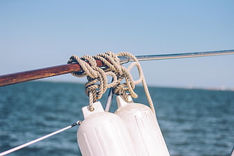 Coiled Rope and White Buoys on Sailboat Rail